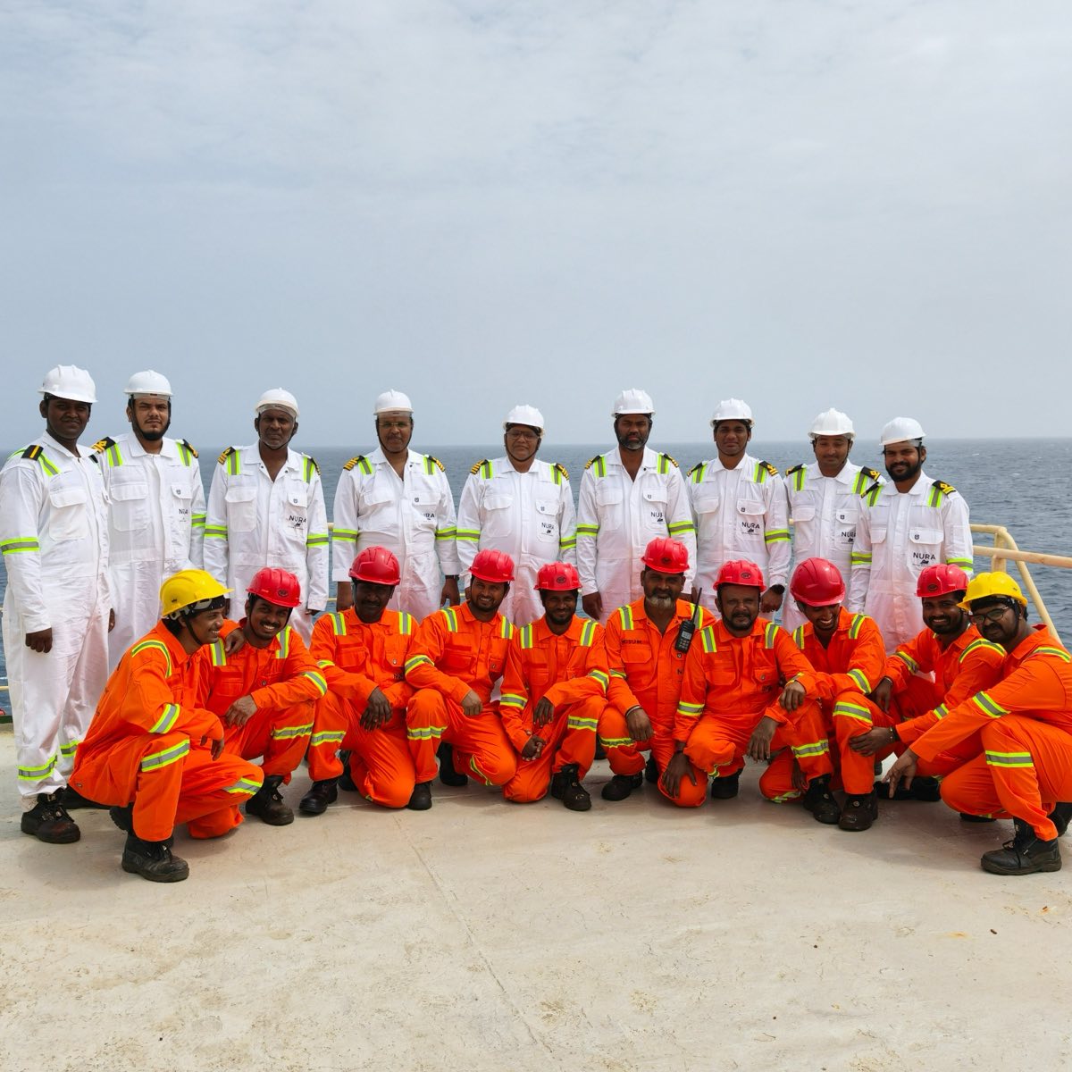 The full crew of the NURA BRIGHT in NURA uniforms, on deck at sea